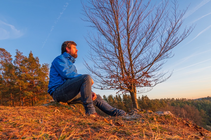 A photograph of Kieran Hayes sitting looking at the sunset.